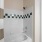 Luxury bathroom at The Morgan Chapel Hill showcasing granite countertops, tub/shower combo, tiled walls, hardwood-style flooring, and spacious cabinet storage.