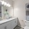 Sleek bathroom design at The Morgan Chapel Hill with granite countertops, tub and shower combination, tiled walls, hardwood-style floors, and built-in cabinet storage